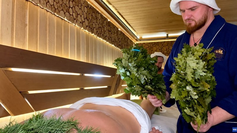 Сергей парит гостя двумя дубовыми вениками